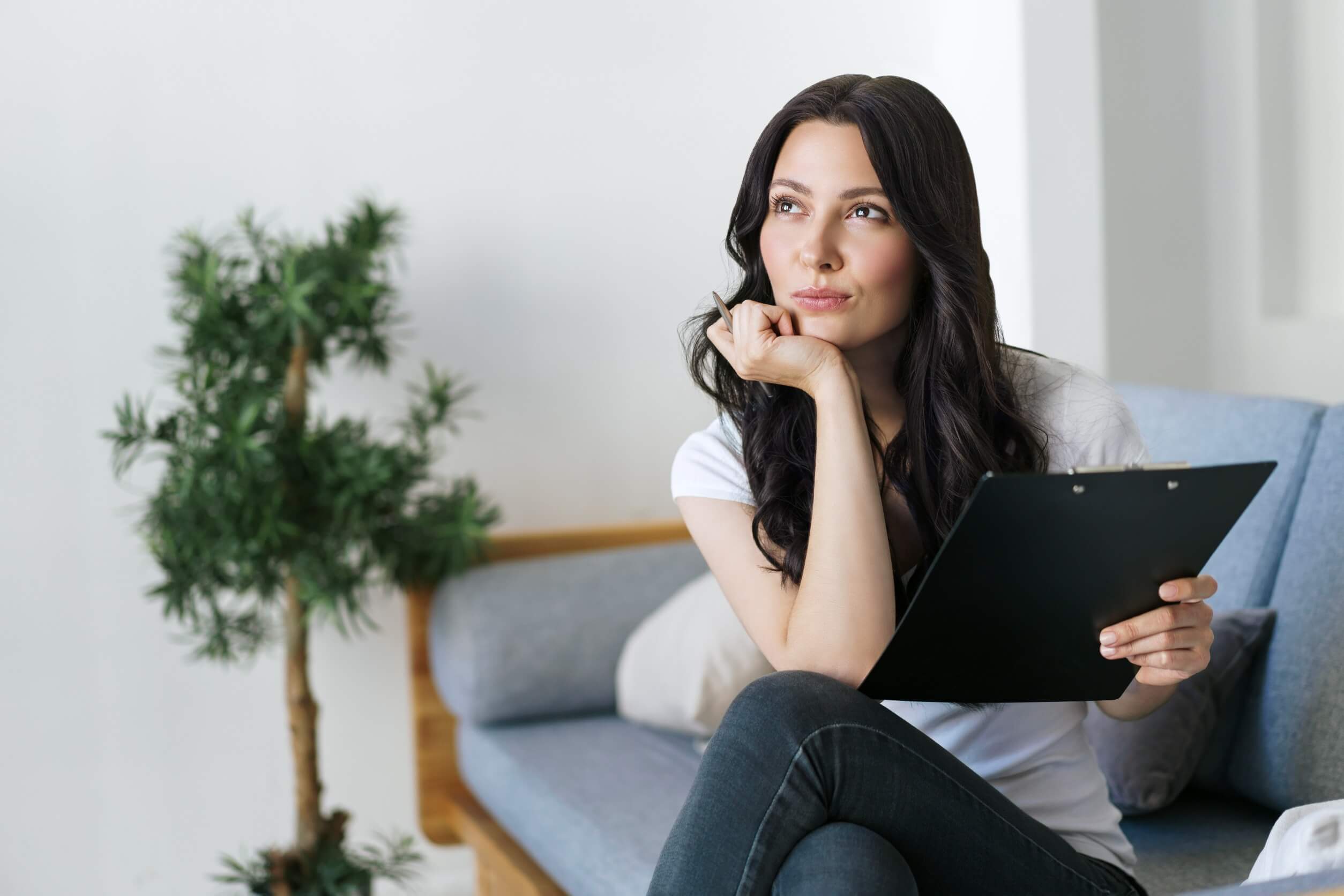 Mujer pensando como hacer un CV para buscar practicas profesionales.