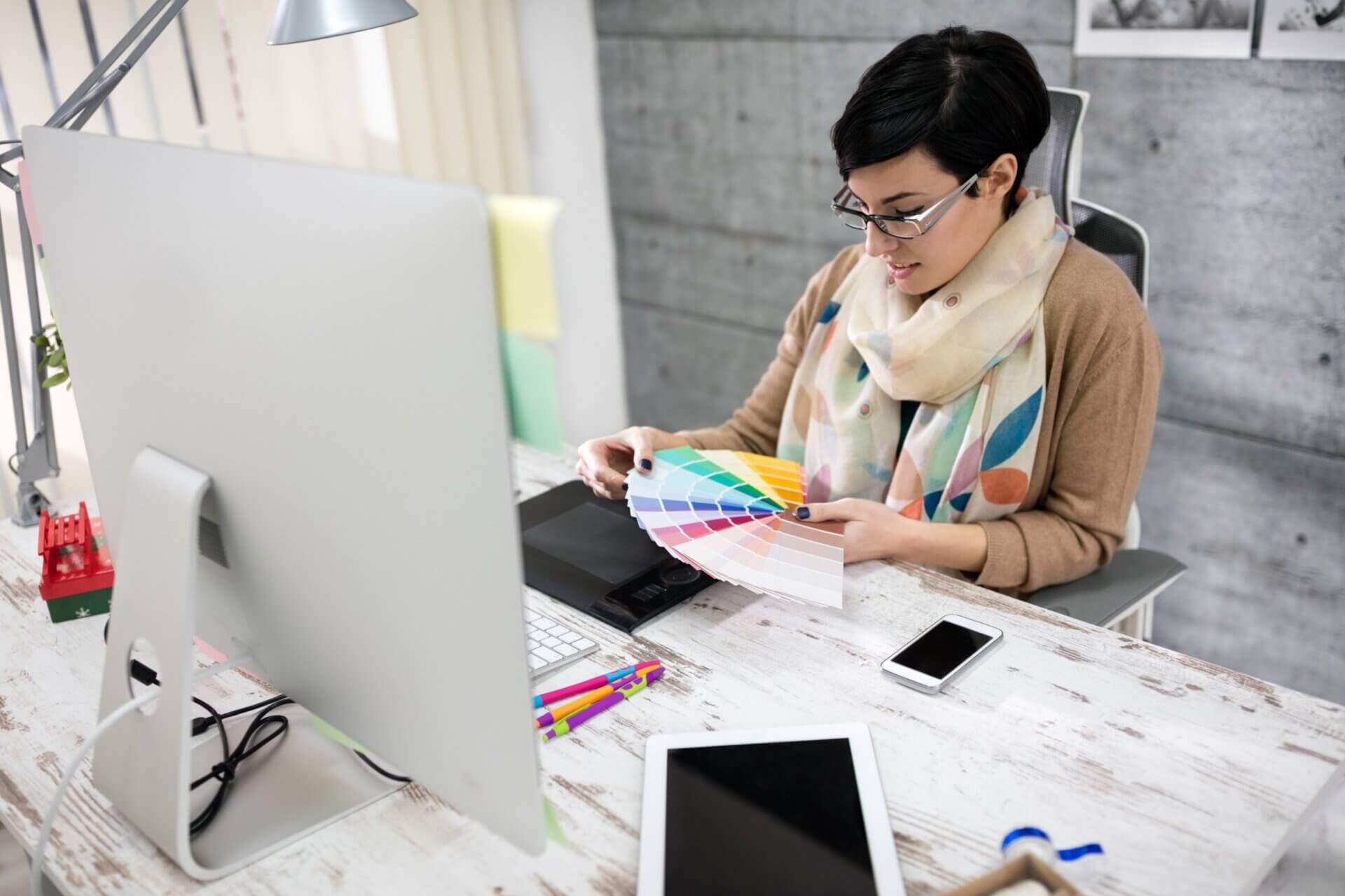 Diseñadora trabaja en su oficina en casa con ordenador 