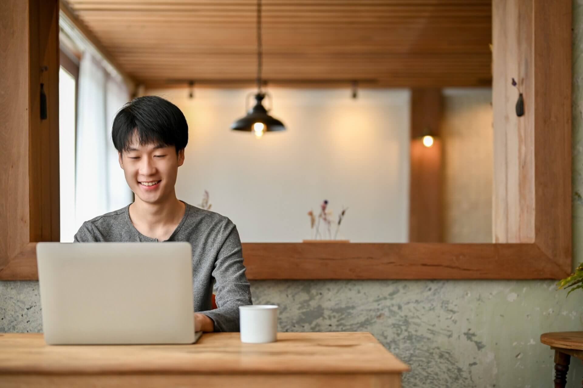 Hombre sonriente trabaja con el ordenador en un café