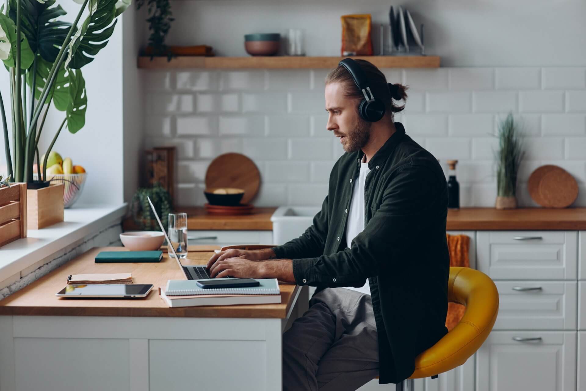 Hombre trabaja con auriculares en oficina en casa