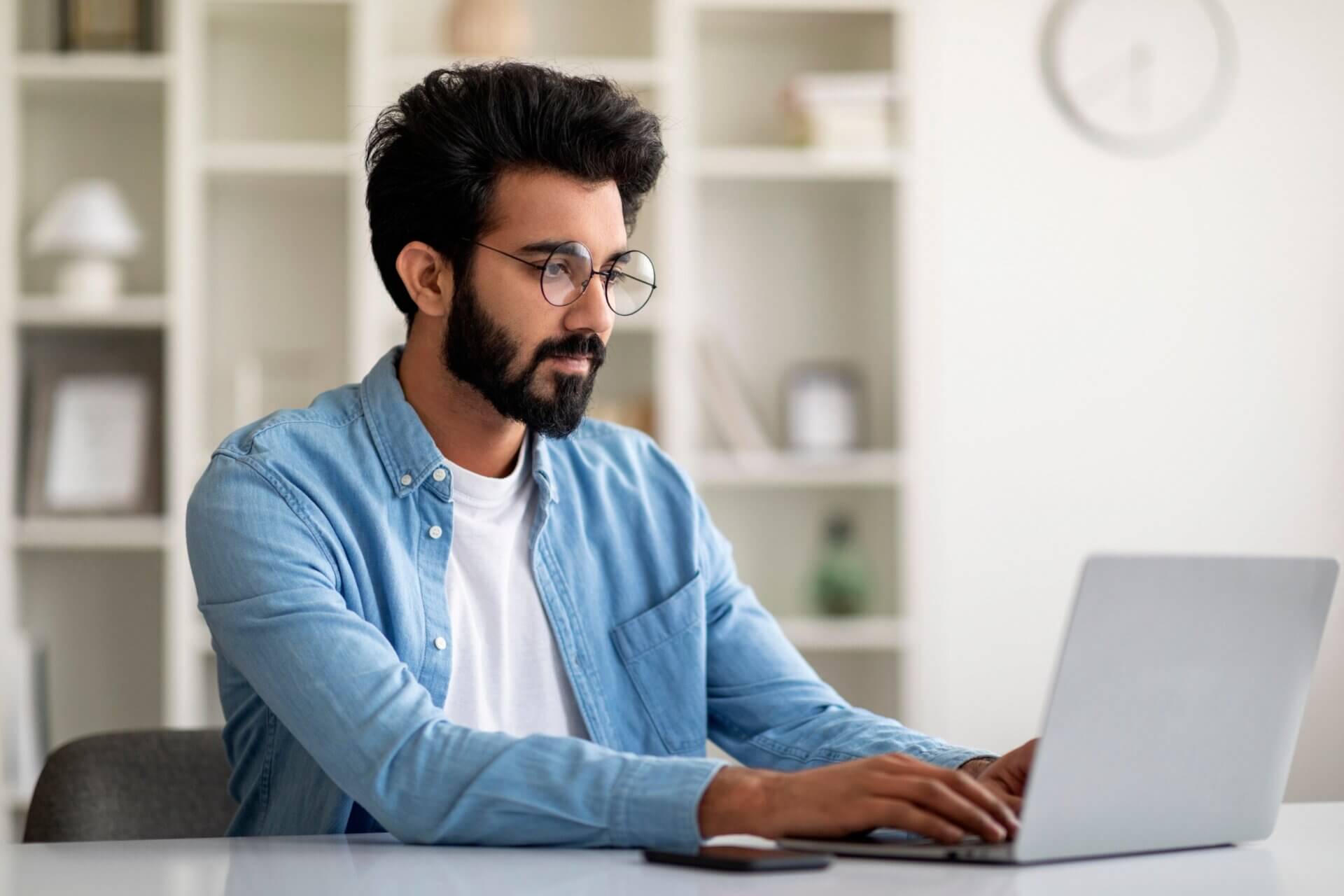 Hombre con gafas trabaja concentrado en el ordenador