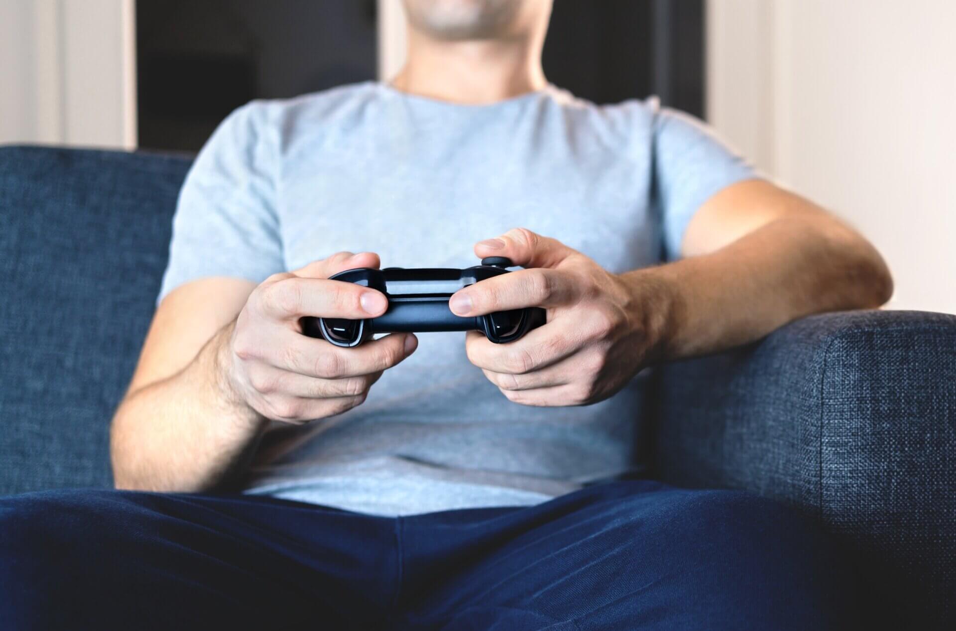 Hombre juega videojuegos desde el sofá