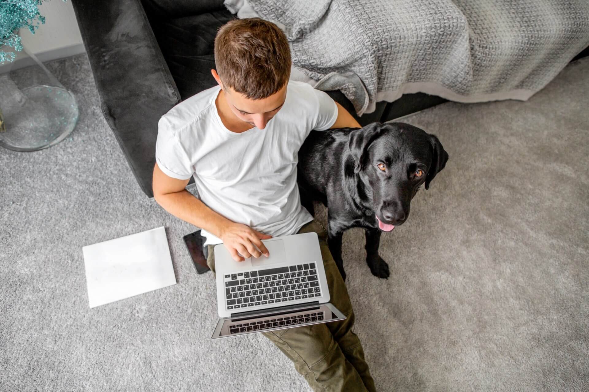 Hombre trabaja con su perro en el ordenador