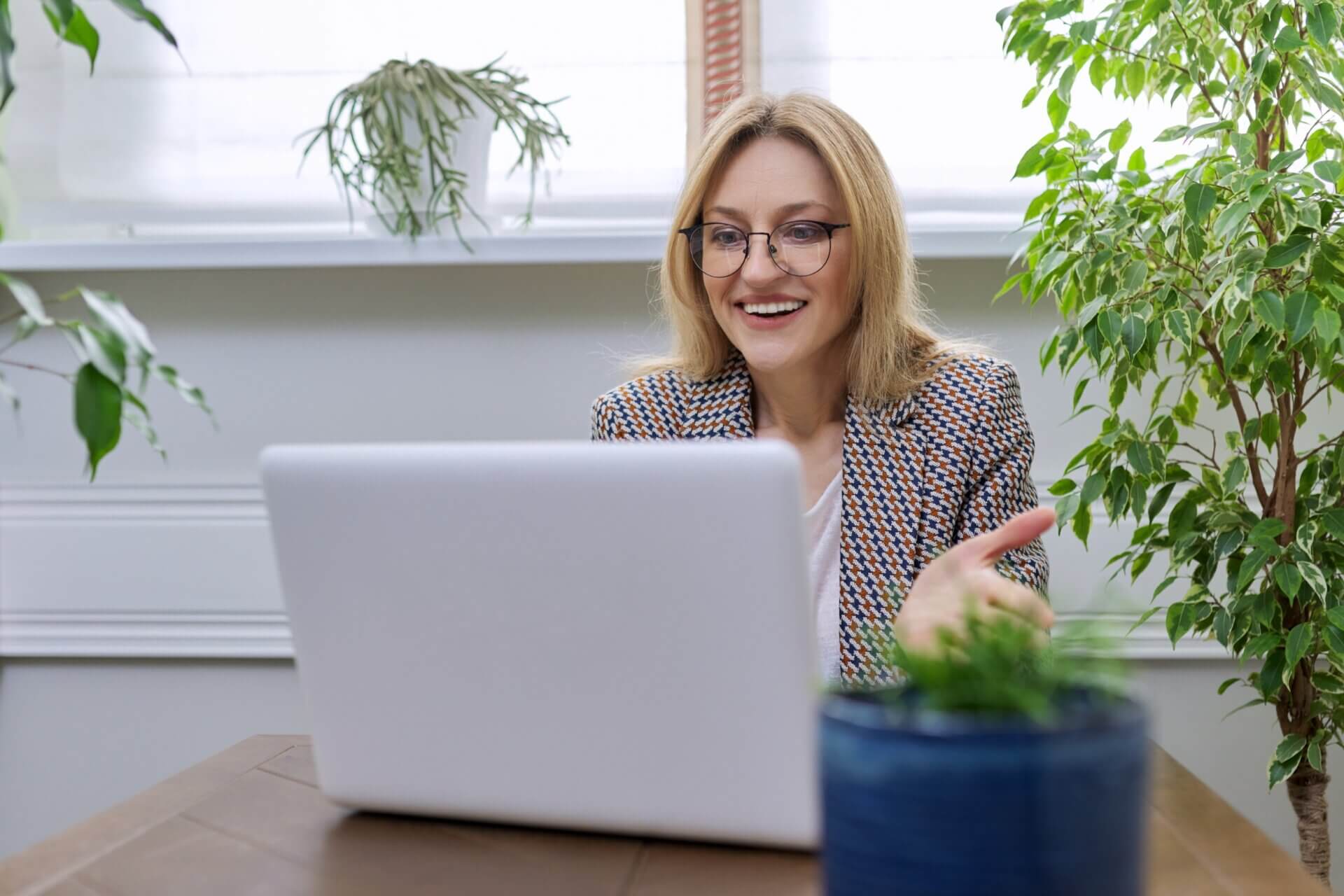 Mujer sonriente con gafas en una videollamada