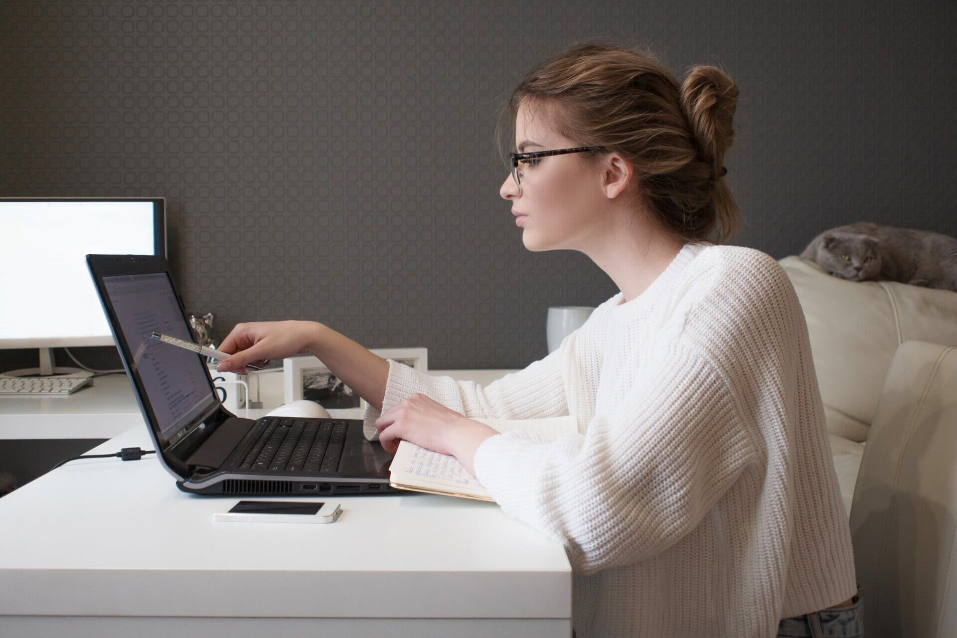 Mujer con gafas trabaja en el ordenador