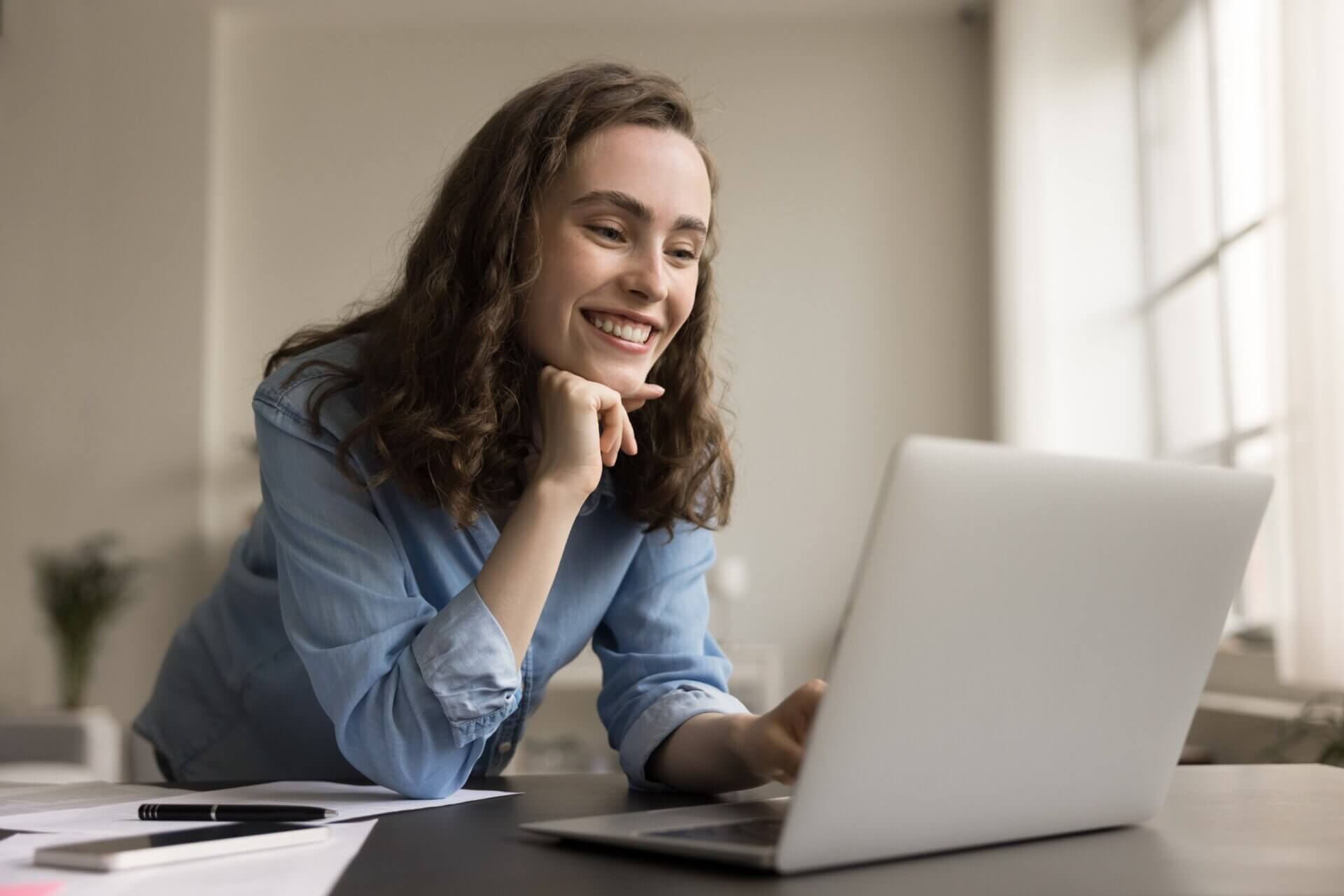 Mujer sonriente trabaja concentrada en el ordenador