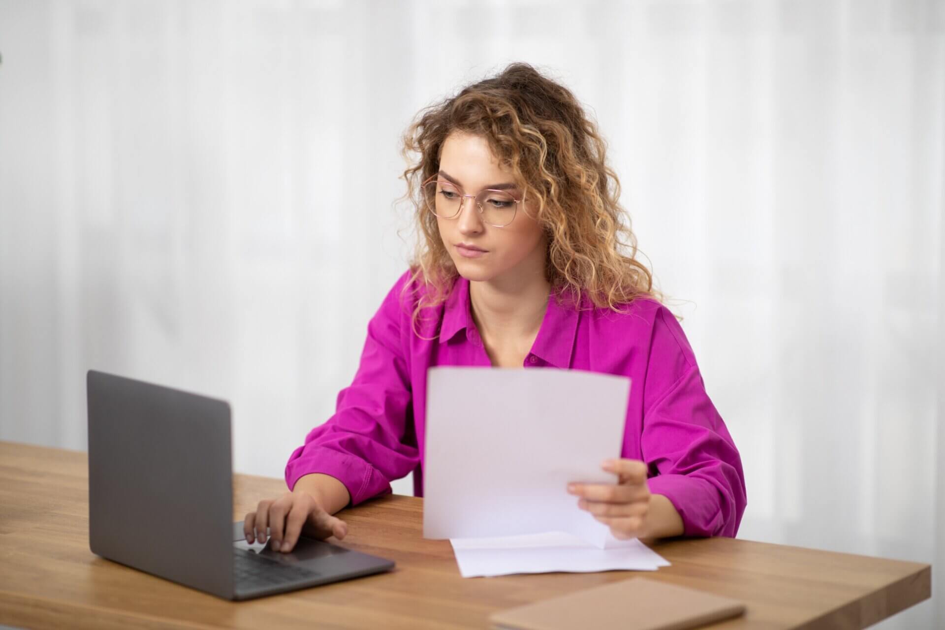 Mujer con gafas trabaja concentrada en el ordenador 