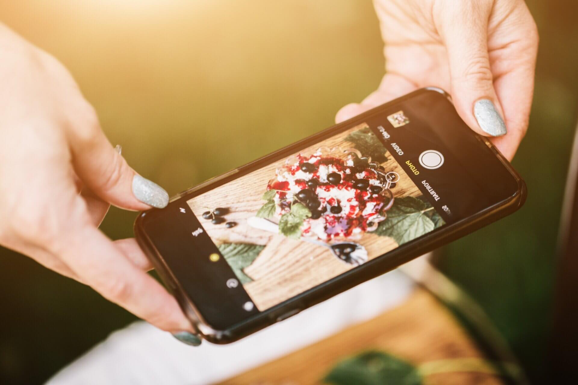 Mujer toma foto comida con teléfono inteligente