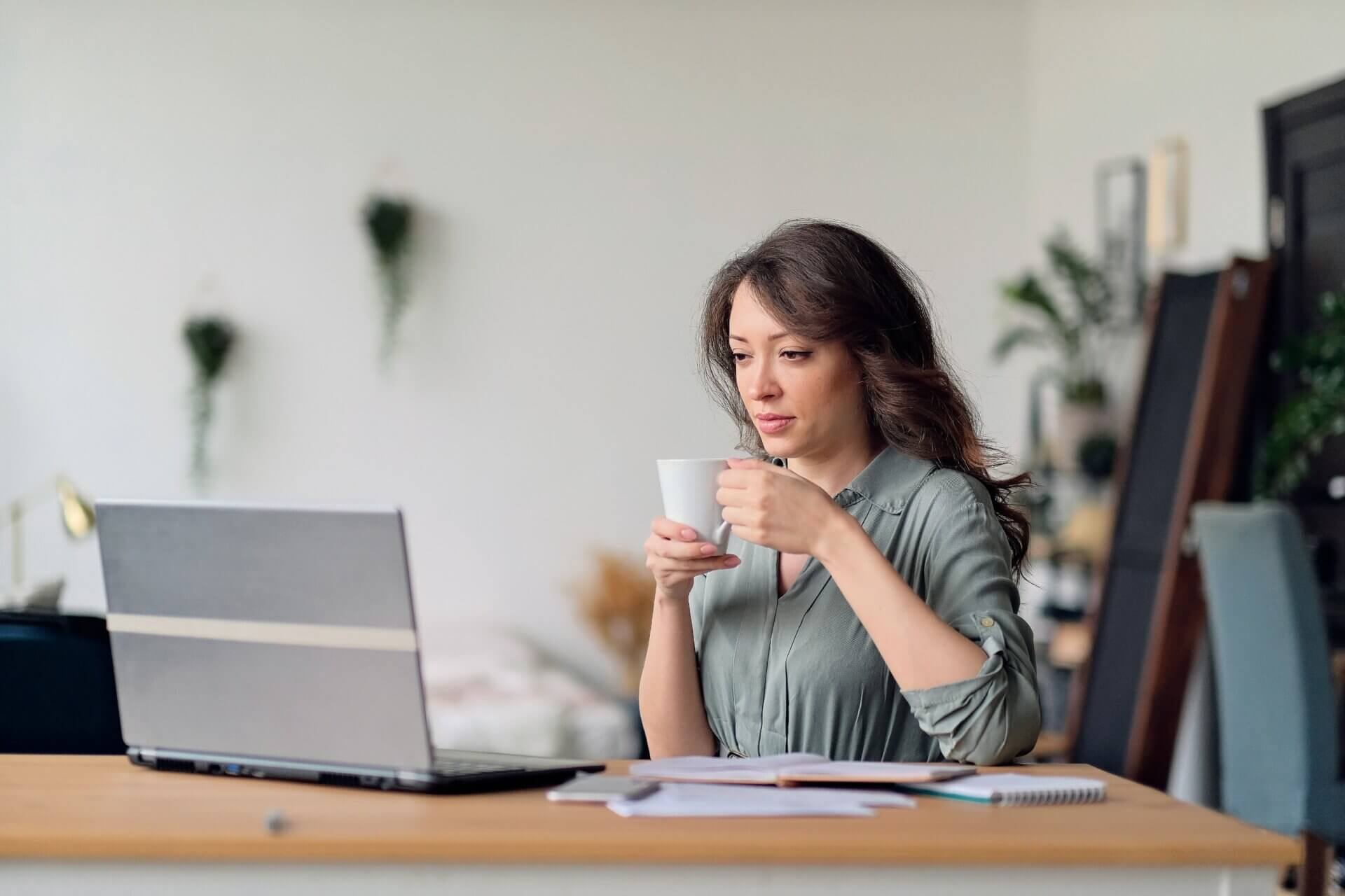 Mujer con taza de café concentrada en el trabajo