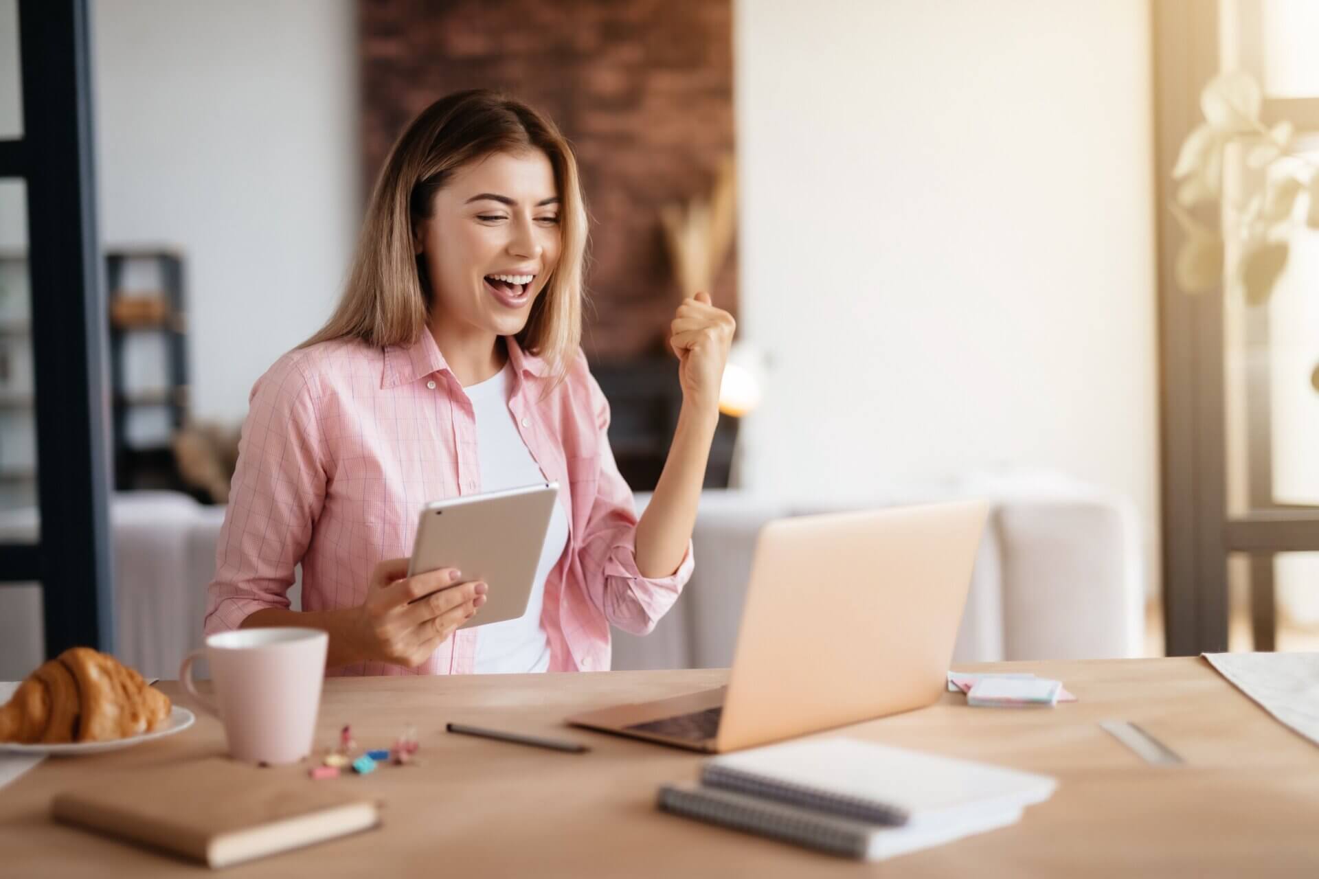 Mujer emocionada trabaja frente al ordenador