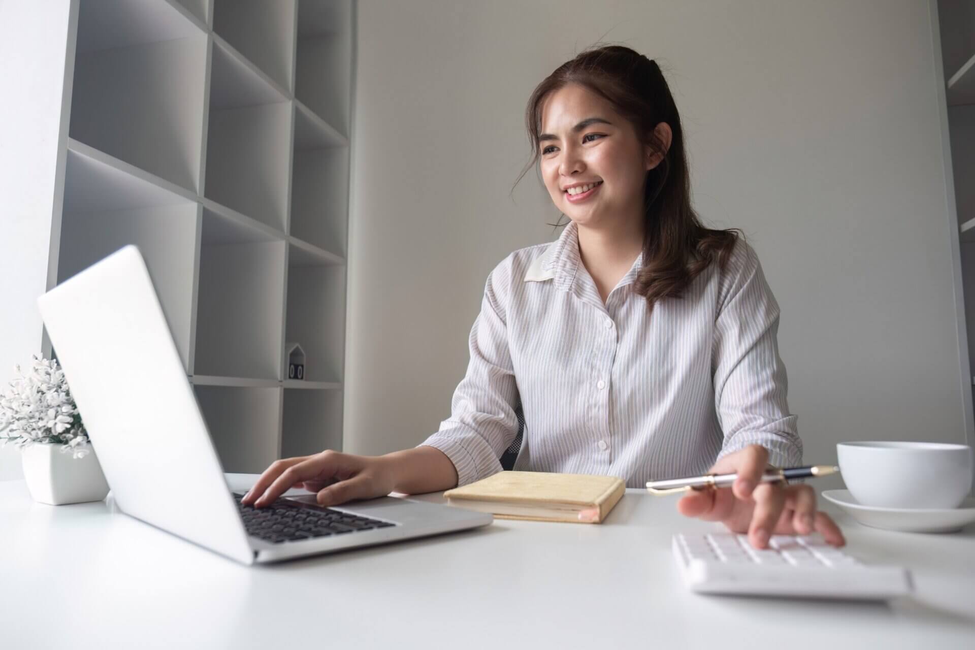 Mujer trabaja sonriente en el ordenador