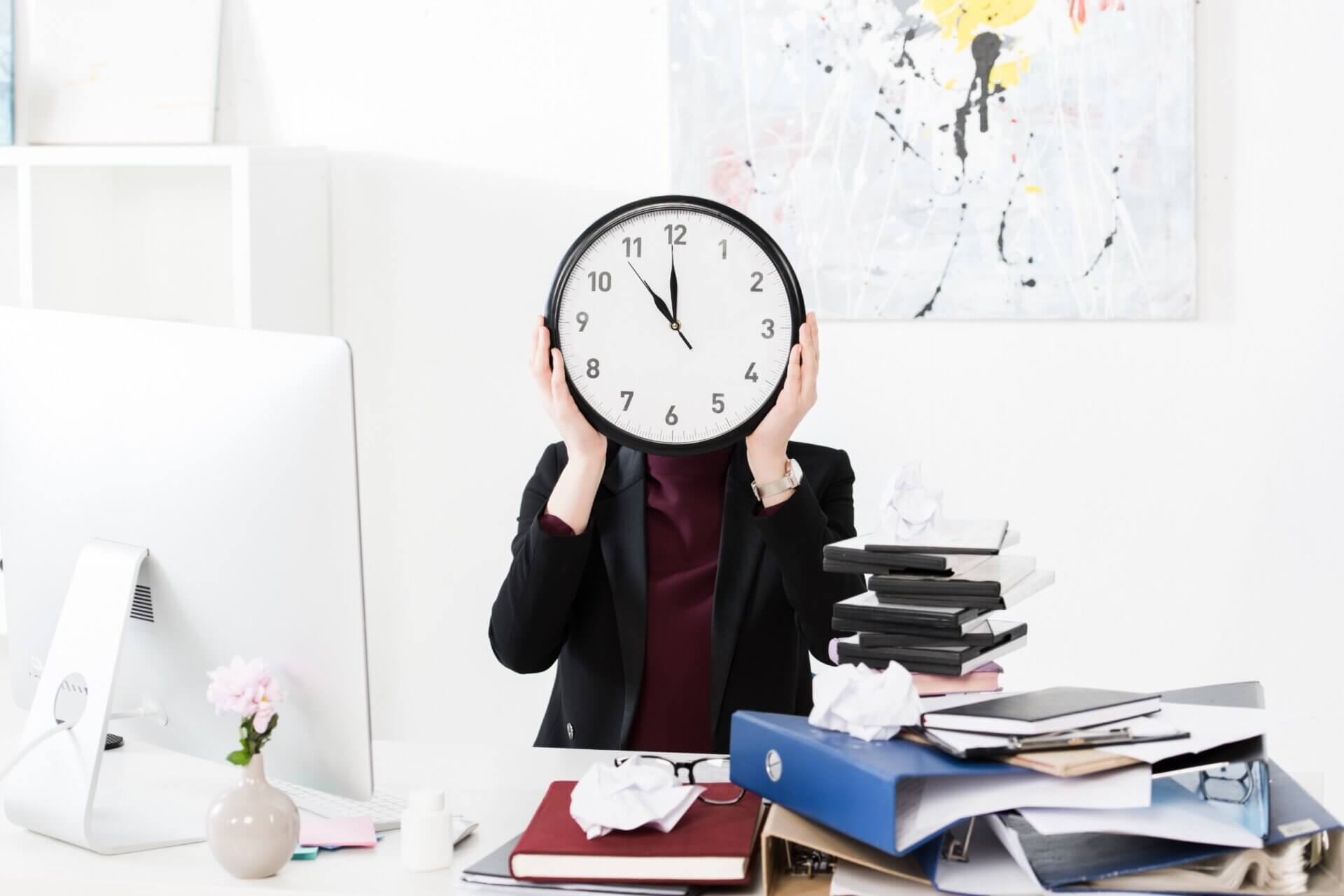 Mujer tapa su rostro con un reloj en la oficina