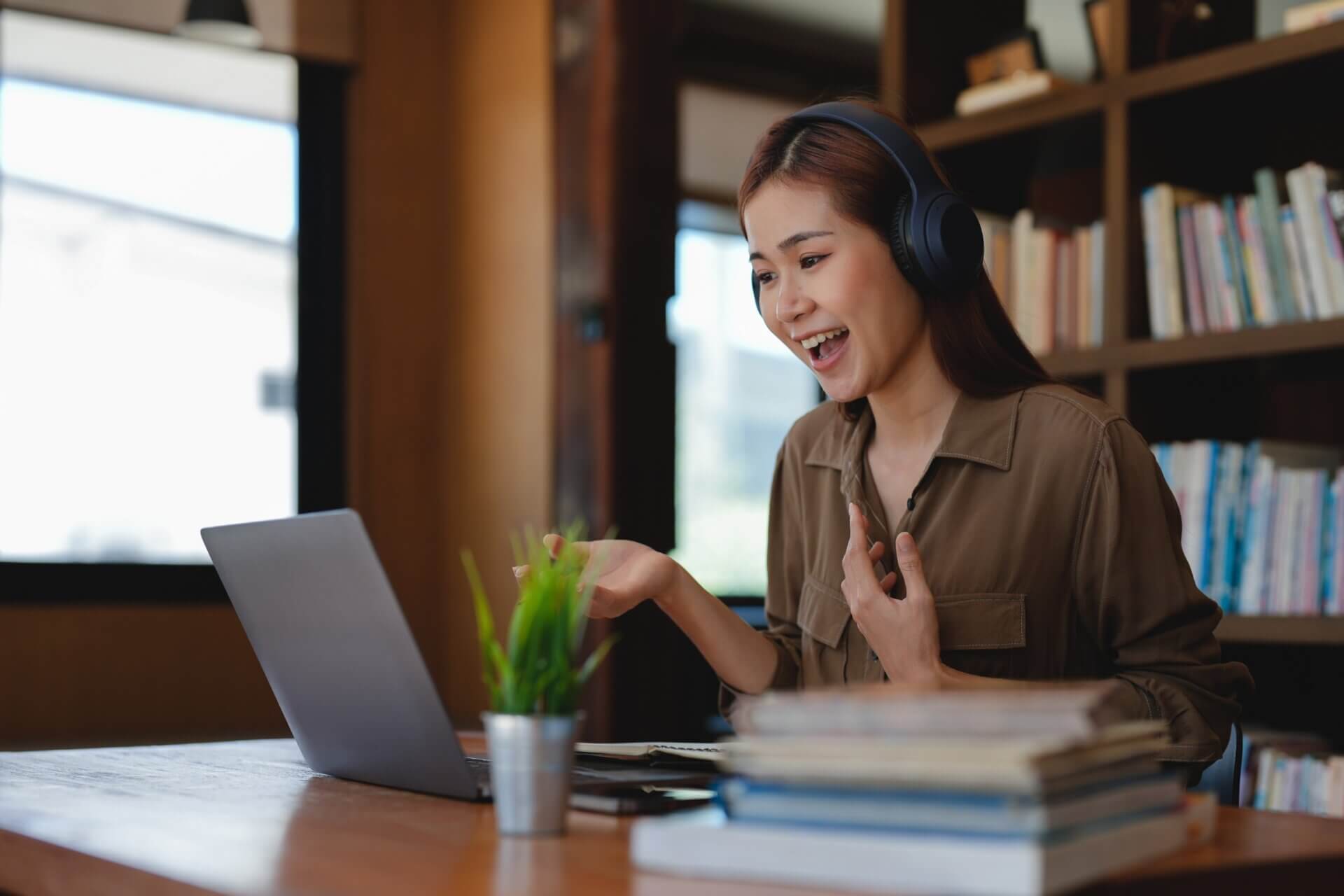 Mujer con auriculares habla en una videollamada 