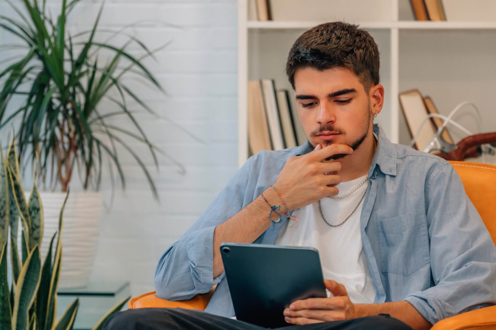 Hombre pensativo trabaja tablet